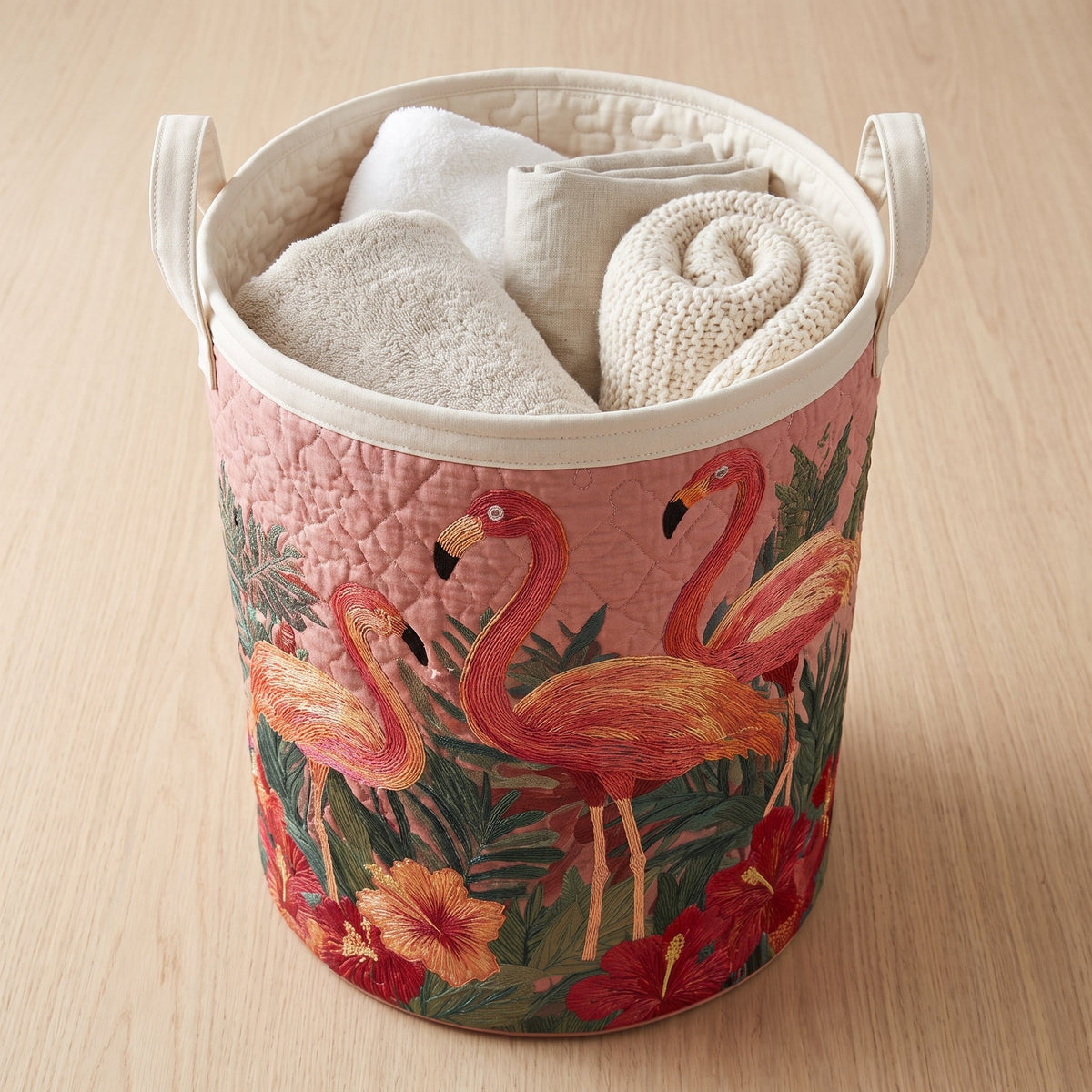 Quilted Laundry Basket - Flamingos in the Sun — filled with folded towels and laundry